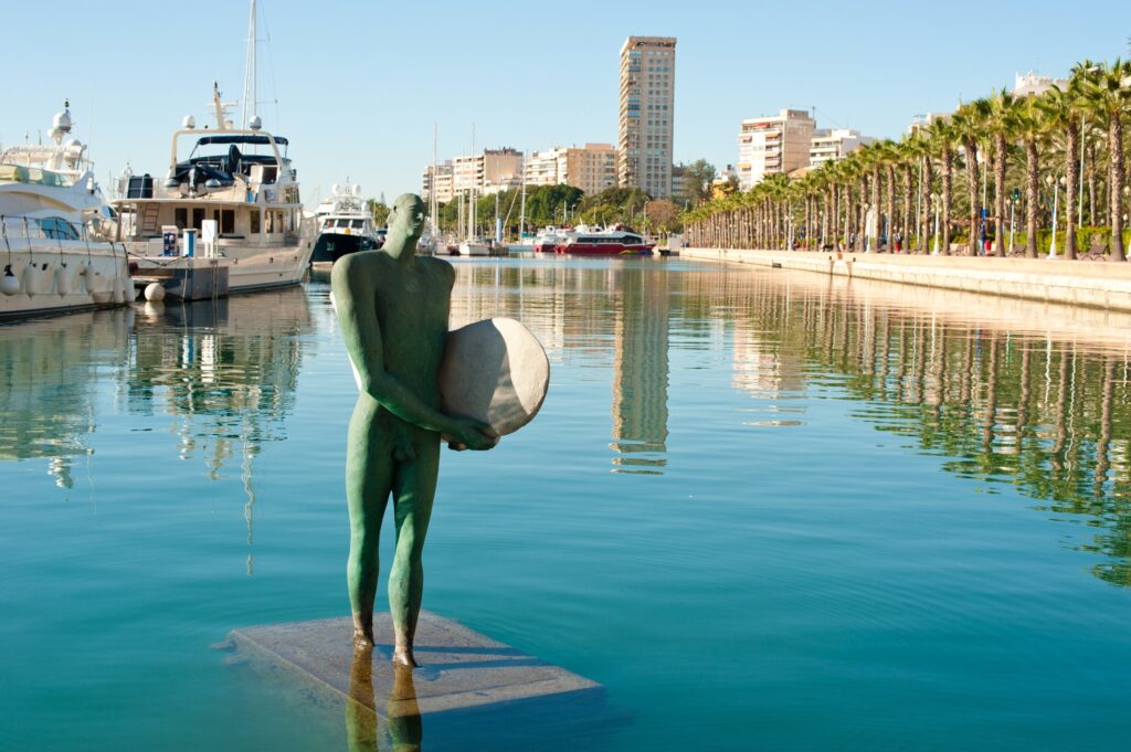 Port d'Alicante avec des bateau et en avant plan une statuette